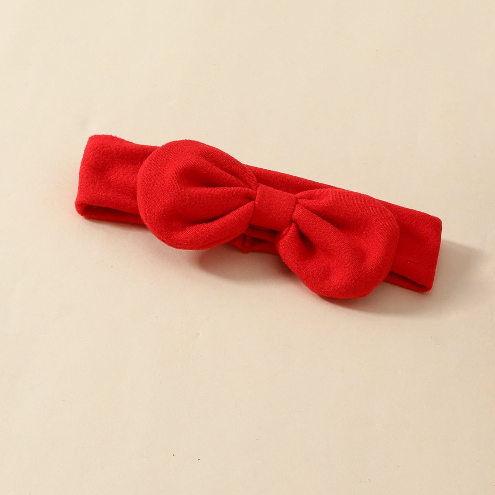 Red baby hairband with a bow, matches Valentine's Day romper.