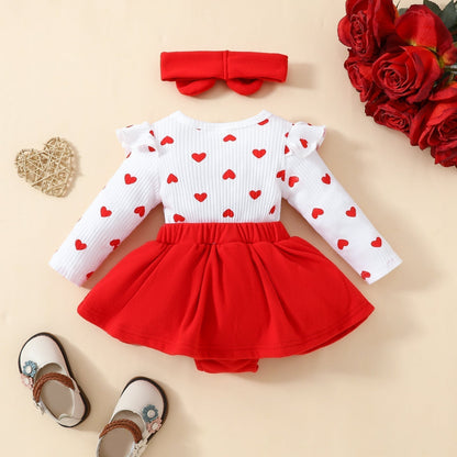 Baby Valentine's Day romper with embroidered hearts, fake suspender design, and matching hairband; crafted from soft knitted fabric for comfort.
