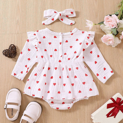 Adorable baby girl Valentine's Day dress with polka dot pattern, long sleeves, pink and white tones.