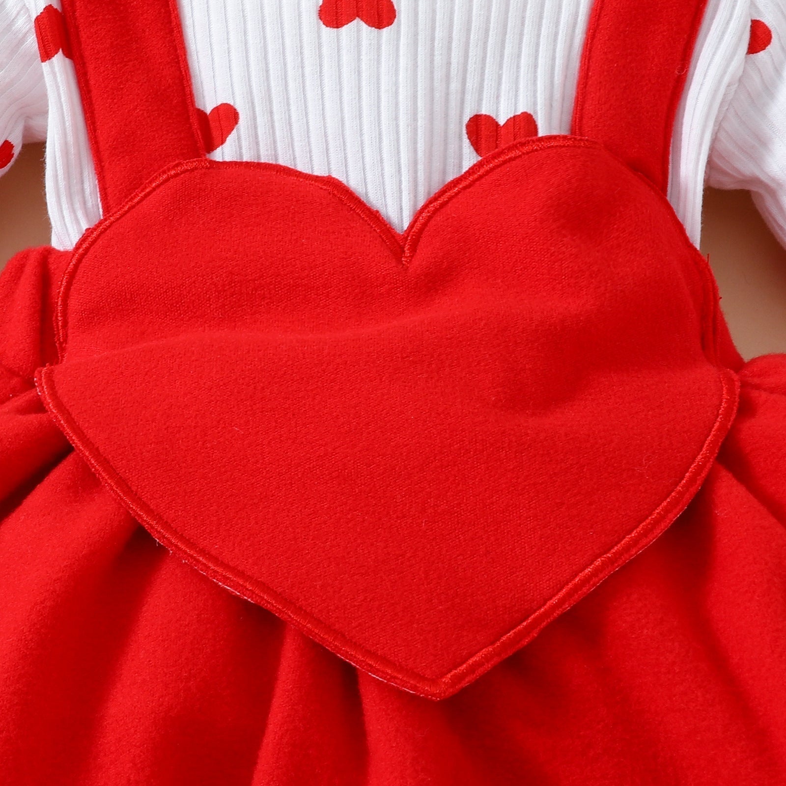 Baby Valentine's Day romper with embroidered heart and fake suspenders in soft knitted fabric.