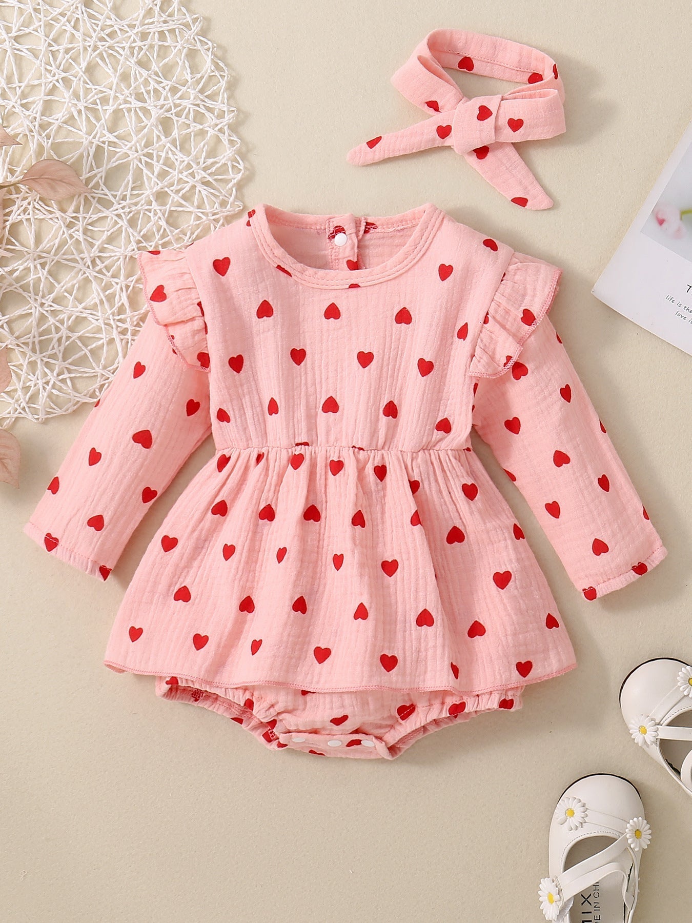 Adorable baby girl Valentine's Day dress with pink and red heart pattern, long sleeves, and matching headband.
