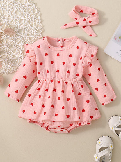Adorable baby girl Valentine's Day dress with pink and red heart pattern, long sleeves, and matching headband.
