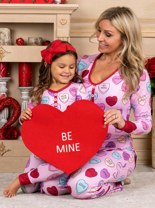 Family in matching heart print pyjamas for Valentine's Day celebration.