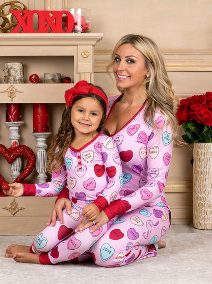 Adorable family in matching heart print pyjamas for Valentine's Day, featuring soft cotton blend and charming design.