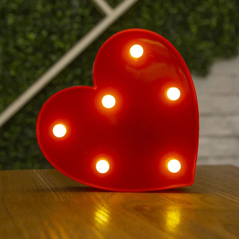 Love Heart LED Lamp with warm white glow on wooden table in cozy setting.