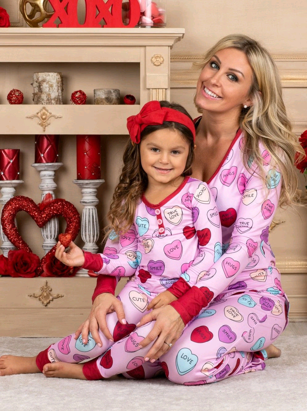 Family in heart print matching pyjamas for Valentine's Day, soft cotton blend.