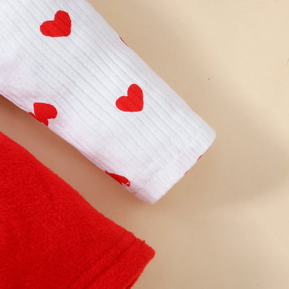 Baby Valentine's Day romper sleeve detail with red hearts on soft knitted fabric.