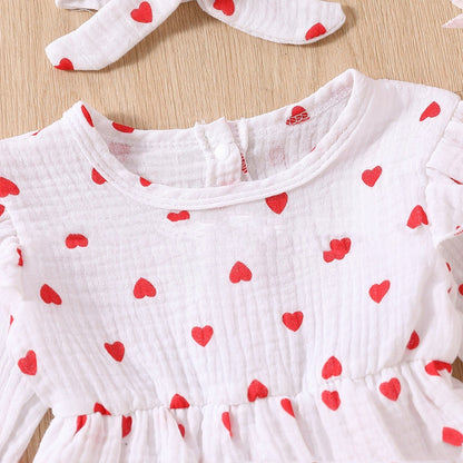Adorable baby girl Valentine's Day dress with red heart pattern, long sleeves, and soft cotton fabric.